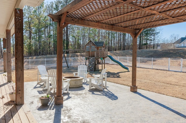 view of patio featuring a playground and an outdoor fire pit