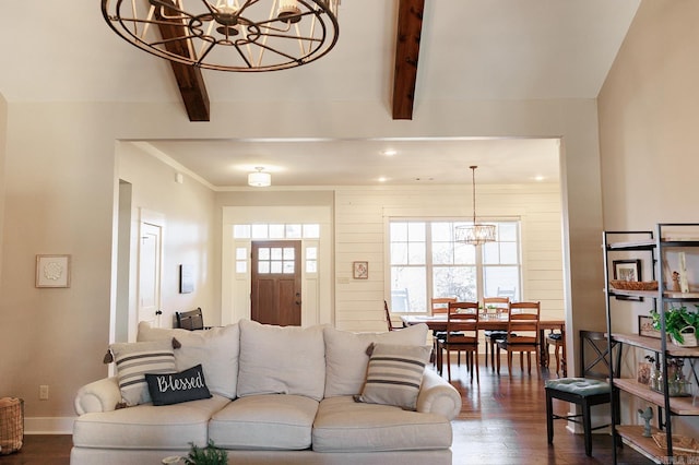 living room with an inviting chandelier, beam ceiling, and dark hardwood / wood-style flooring