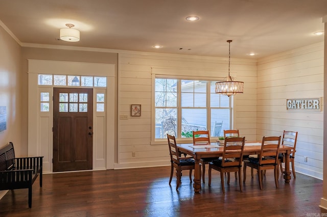 dining room featuring dark hardwood / wood-style flooring, ornamental molding, and an inviting chandelier