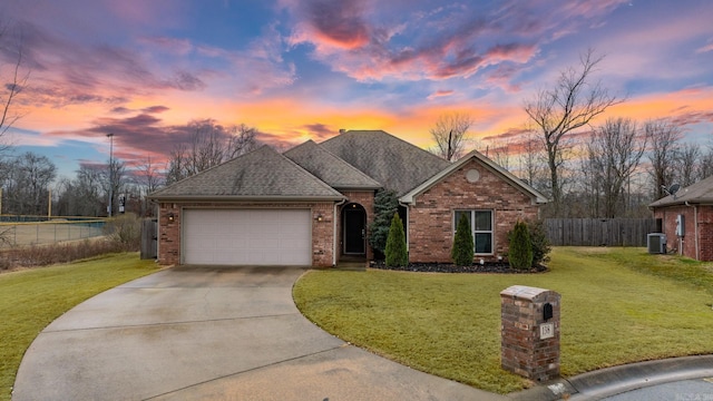 ranch-style house with a garage and a lawn