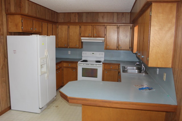 kitchen with white appliances, kitchen peninsula, sink, and a textured ceiling