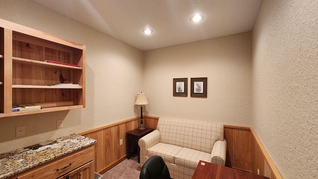 sitting room with wooden walls and carpet