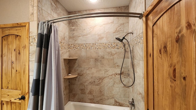 bathroom with shower / bathtub combination with curtain and a textured ceiling