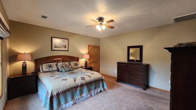 bedroom with ceiling fan, light colored carpet, and a textured ceiling