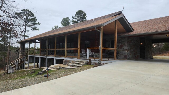 rear view of property featuring a sunroom