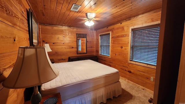 bedroom with ceiling fan, wood ceiling, and wooden walls