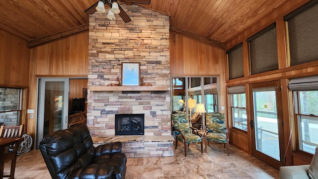 living room featuring a stone fireplace, wooden walls, and wooden ceiling