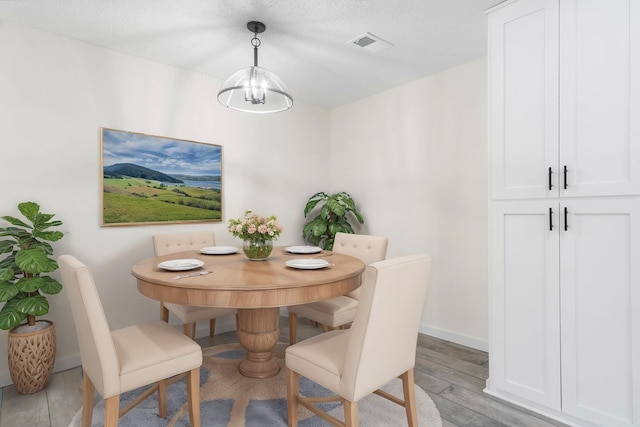 dining room with a chandelier and light hardwood / wood-style floors