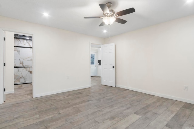 unfurnished room with ceiling fan and light wood-type flooring