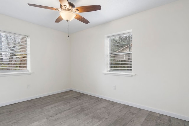 spare room featuring ceiling fan, a healthy amount of sunlight, and light wood-type flooring