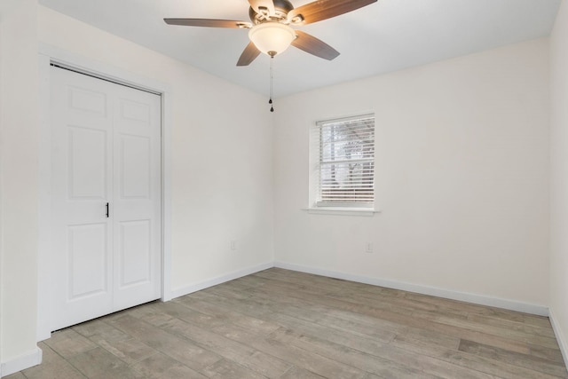 unfurnished bedroom with light hardwood / wood-style flooring, a closet, and ceiling fan