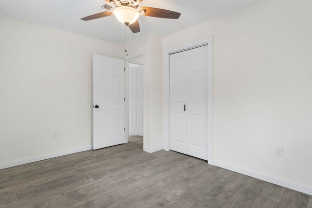 unfurnished bedroom with ceiling fan, wood-type flooring, and a closet