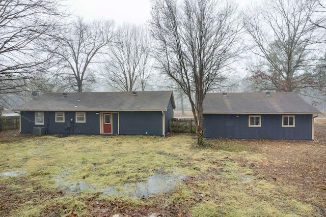 rear view of property with cooling unit and a yard