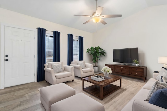 living room featuring vaulted ceiling, ceiling fan, and light wood-type flooring