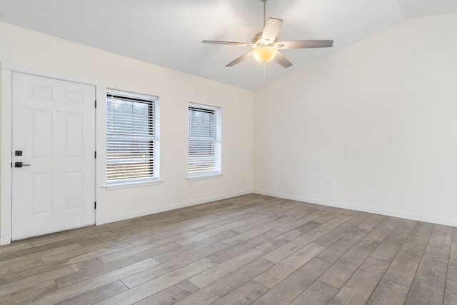 empty room with lofted ceiling, ceiling fan, and light hardwood / wood-style flooring