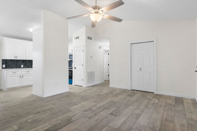 unfurnished living room with light hardwood / wood-style flooring, high vaulted ceiling, and ceiling fan