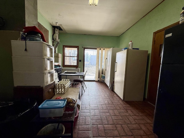 kitchen featuring white fridge and black fridge