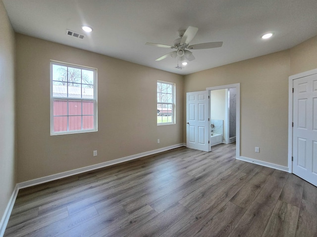 111 Brigance St, Marked Tree, AR 72365 - unfurnished bedroom featuring ceiling fan, ensuite bath, and light hardwood / wood-style floors