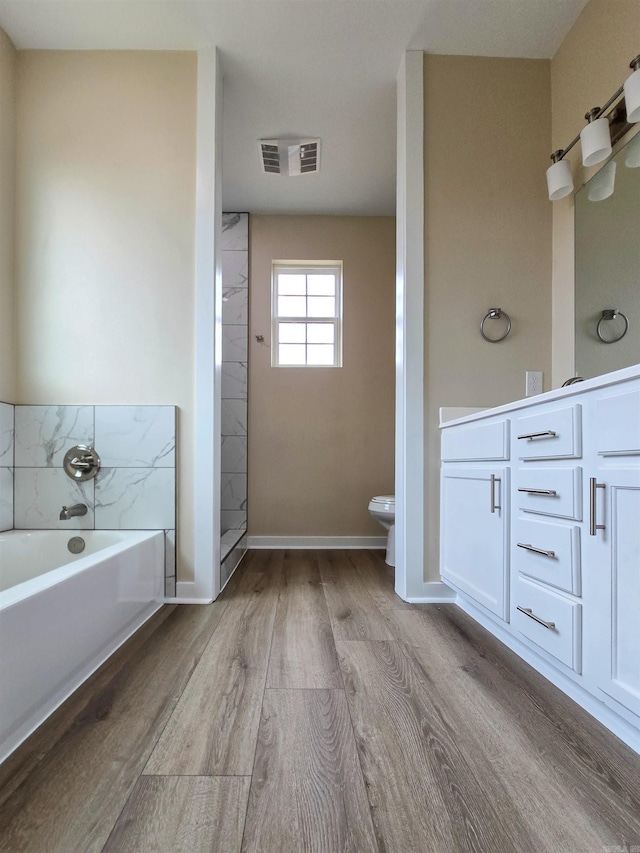 111 Brigance St, Marked Tree, AR 72365 - bathroom with wood-type flooring, a washtub, vanity, and toilet