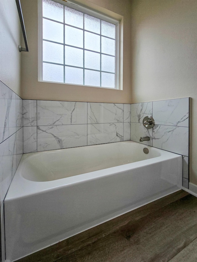 111 Brigance St, Marked Tree, AR 72365 - bathroom with hardwood / wood-style floors, a healthy amount of sunlight, and a bath