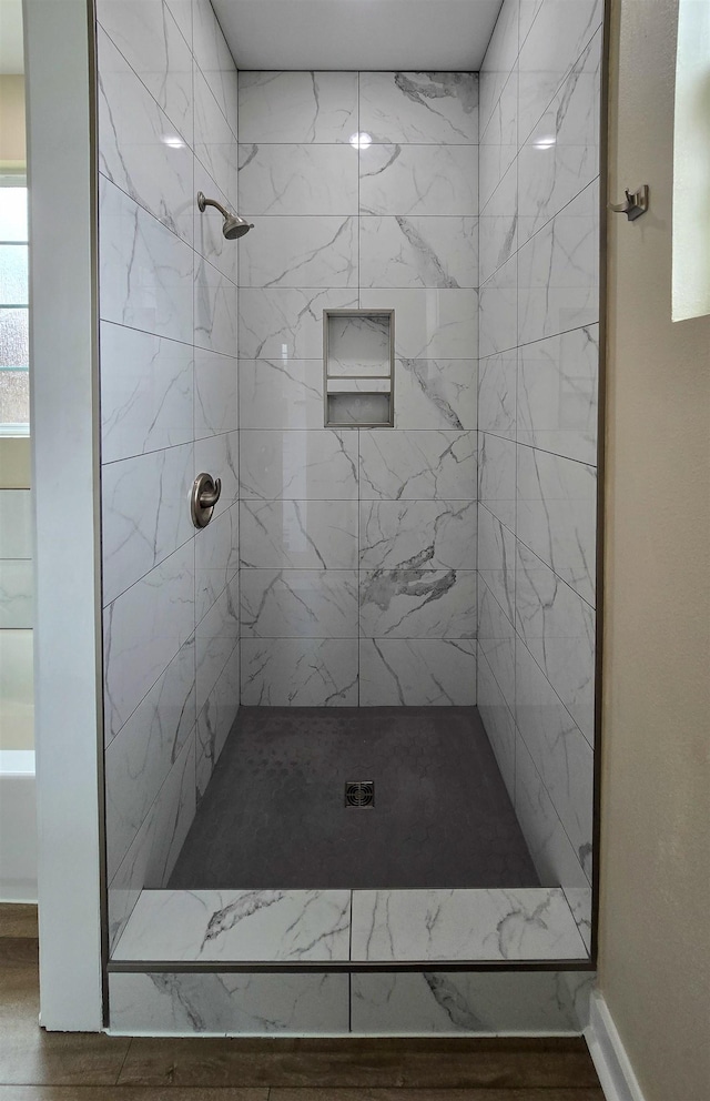 111 Brigance St, Marked Tree, AR 72365 - bathroom featuring hardwood / wood-style floors and a tile shower