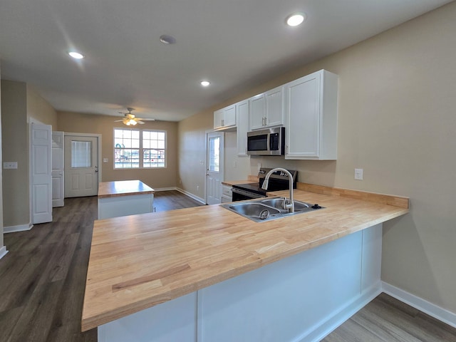 111 Brigance St, Marked Tree, AR 72365 - kitchen with range with electric cooktop, dark hardwood / wood-style floors, white cabinetry, sink, and kitchen peninsula