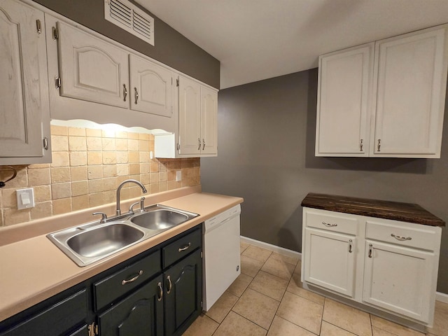 kitchen with white cabinetry, dishwasher, sink, decorative backsplash, and light tile patterned floors