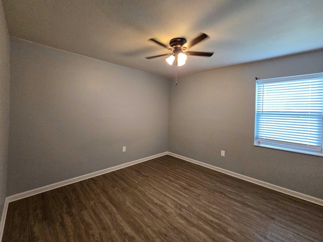 spare room with dark wood-type flooring and ceiling fan