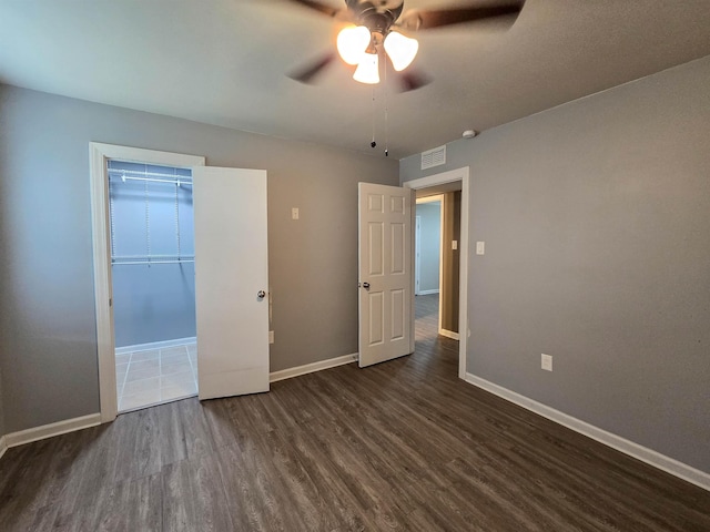 unfurnished bedroom featuring dark hardwood / wood-style floors and ceiling fan