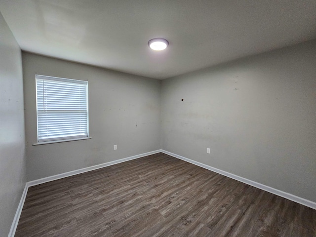 empty room with dark hardwood / wood-style flooring