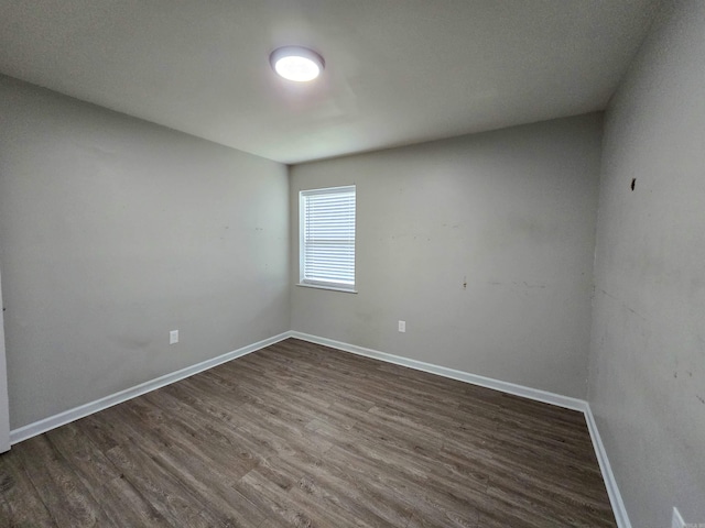 unfurnished room with dark wood-type flooring