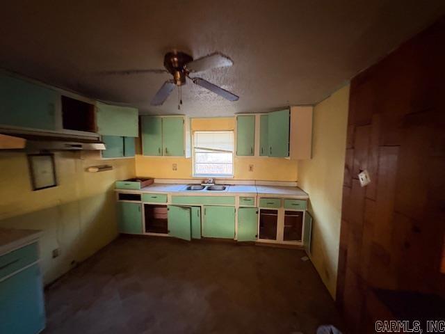 kitchen featuring ceiling fan, sink, and green cabinets