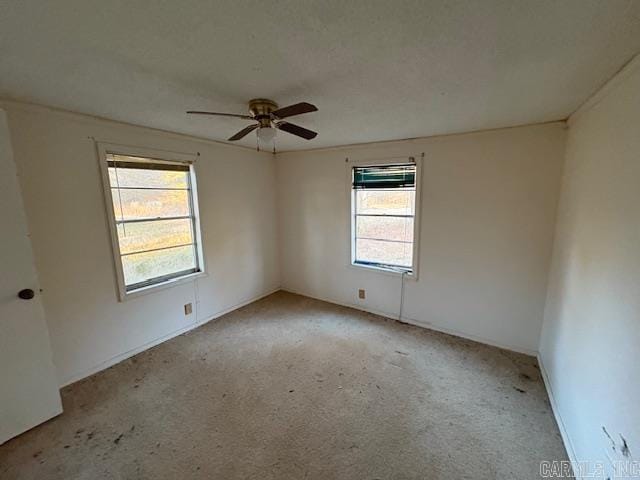 spare room featuring light colored carpet and ceiling fan