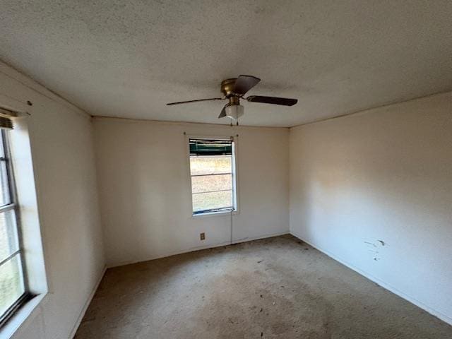 spare room featuring ceiling fan, carpet floors, and a textured ceiling