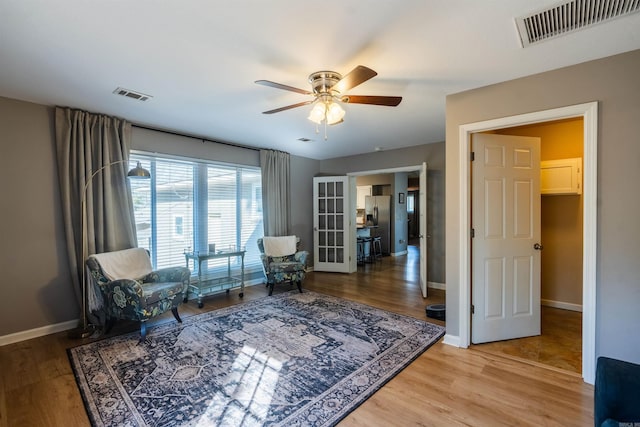 living area featuring hardwood / wood-style flooring and ceiling fan