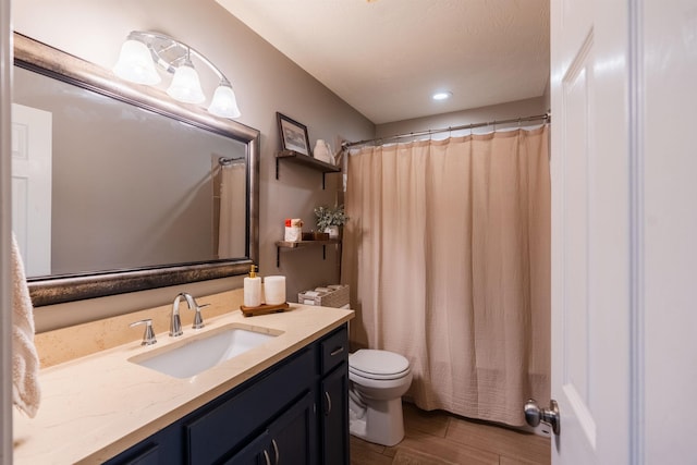 bathroom featuring hardwood / wood-style flooring, vanity, toilet, and curtained shower