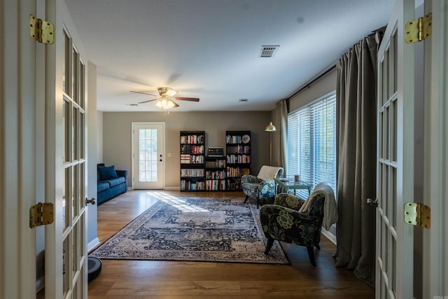 living area featuring hardwood / wood-style flooring, a wealth of natural light, french doors, and ceiling fan