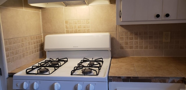 kitchen featuring white gas range oven, tile patterned floors, and range hood