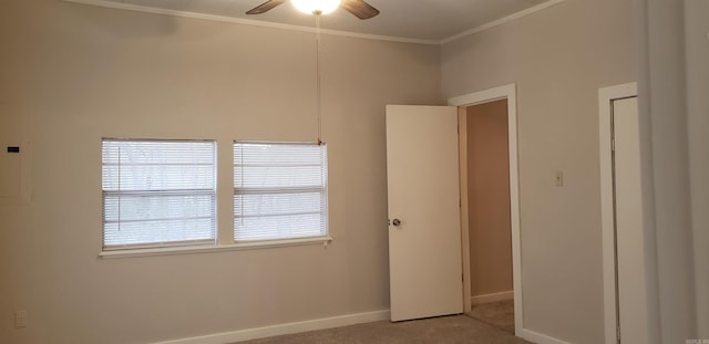 spare room featuring crown molding, ceiling fan, and light carpet