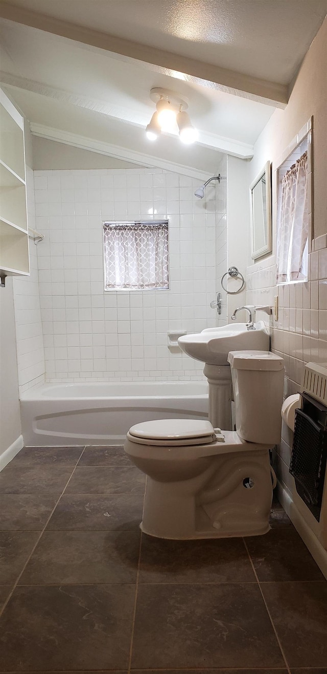 full bathroom with tile patterned flooring, tile walls, heating unit, toilet, and tiled shower / bath