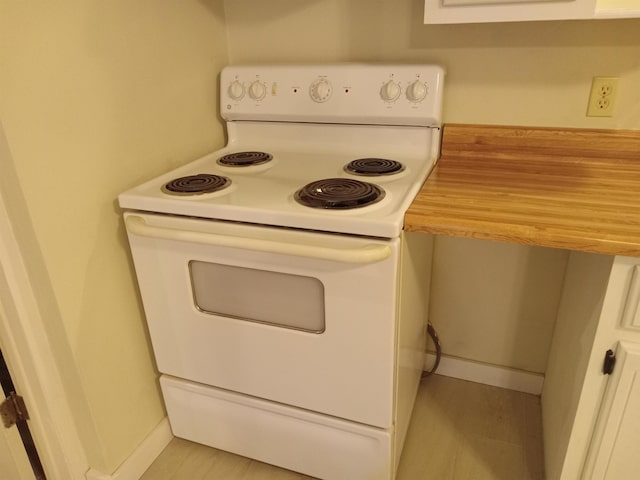 kitchen featuring white electric stove, white cabinetry, and light hardwood / wood-style flooring