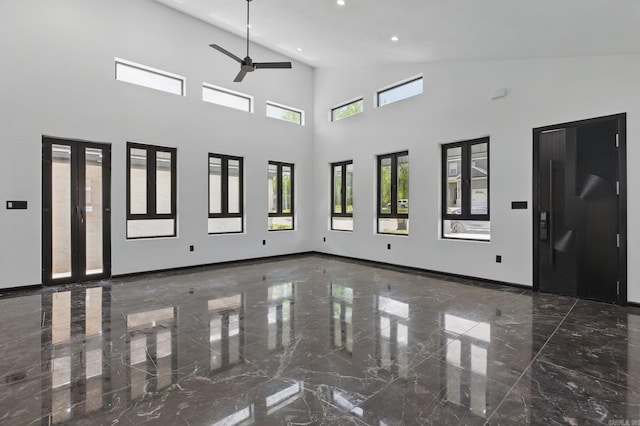 empty room with a towering ceiling, baseboards, recessed lighting, a ceiling fan, and marble finish floor