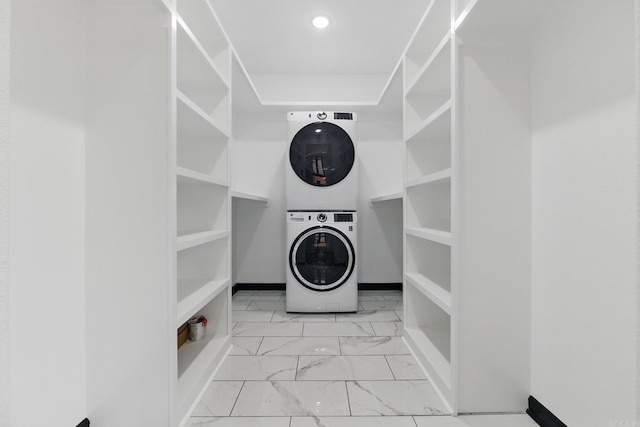 washroom featuring marble finish floor, laundry area, stacked washer and clothes dryer, and recessed lighting