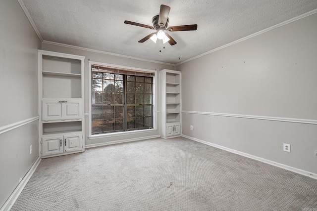 unfurnished room featuring ceiling fan, crown molding, light colored carpet, and a textured ceiling