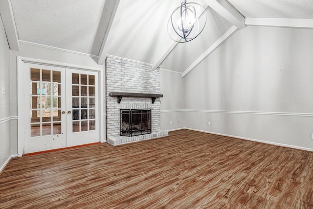 unfurnished living room featuring wood-type flooring, a fireplace, lofted ceiling with beams, and a textured ceiling