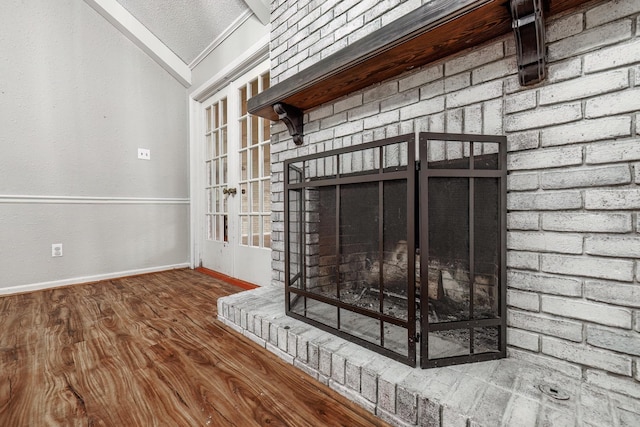 room details featuring a brick fireplace, ornamental molding, hardwood / wood-style floors, and a textured ceiling