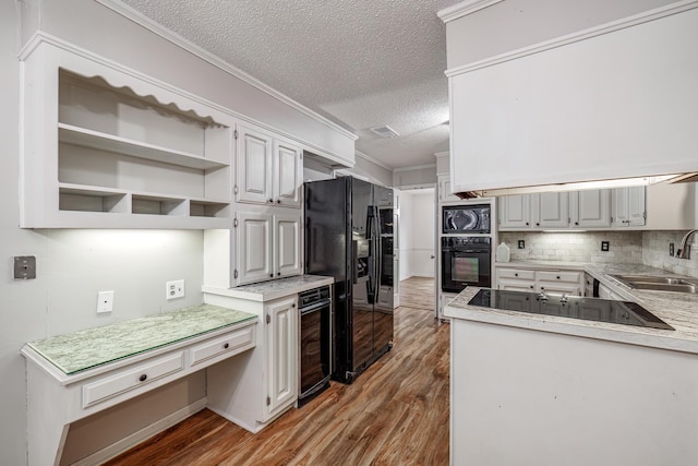 kitchen featuring sink, black appliances, beverage cooler, and white cabinets