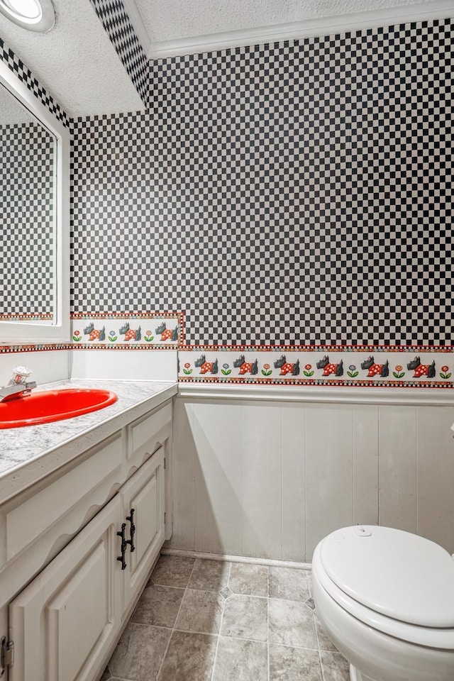 bathroom with vanity, toilet, and a textured ceiling