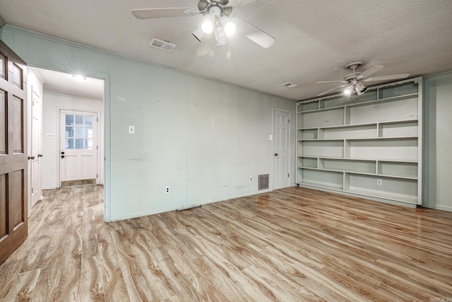 interior space with crown molding, ceiling fan, a textured ceiling, and light wood-type flooring