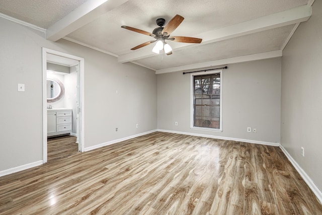 spare room with beamed ceiling, ceiling fan, a textured ceiling, and light wood-type flooring